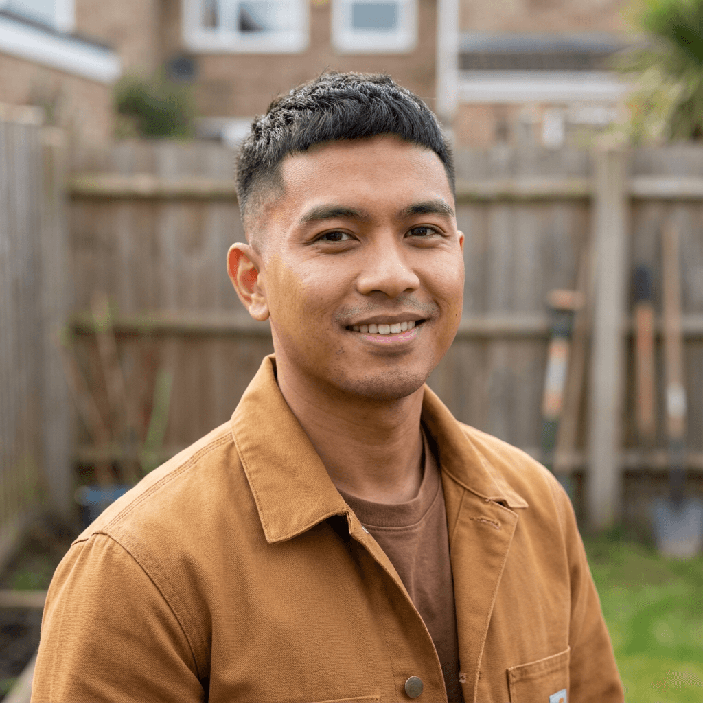 Male homeowner standing beside a house in work attire